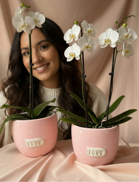 Mujer con orquídeas en pieza rosada LOVE
